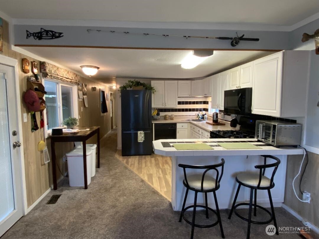 17103 Spanaway Loop Road South, Unit 15 Spanaway, WA 98387 - Photo 7 of 17 a kitchen with a refrigerator and a stove top open