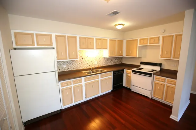 a kitchen with granite countertop white cabinets and white appliances