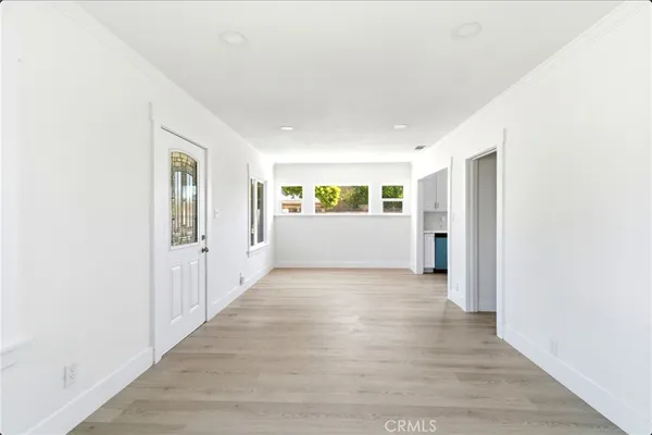 a view of a kitchen with refrigerator and white cabinets