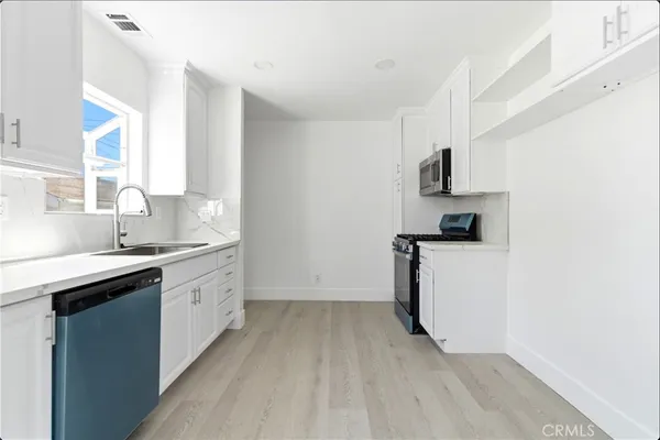 a kitchen with white cabinets and a sink