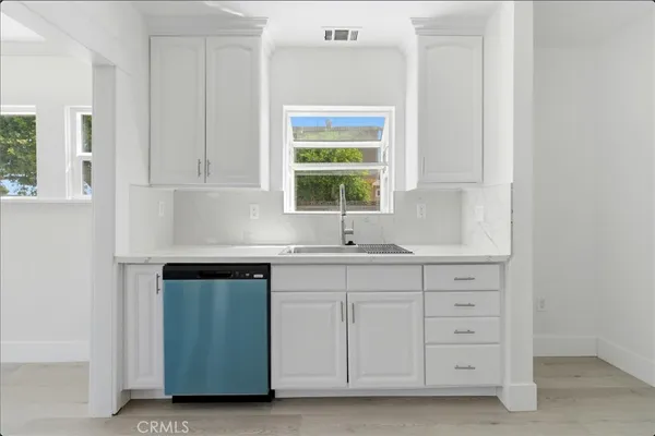a kitchen with granite countertop a sink a stove and cabinets