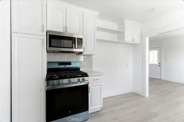 a kitchen with cabinets appliances and a window
