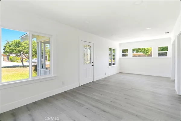 a view of a big room with wooden floor and windows
