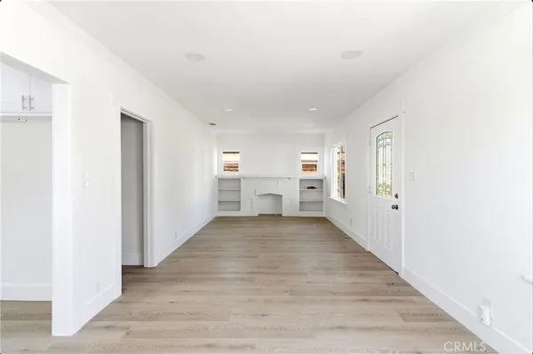 a view of empty room with wooden floor and window