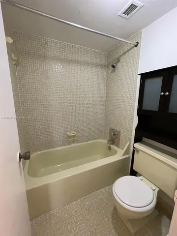 a white bath tub sitting next to a toilet