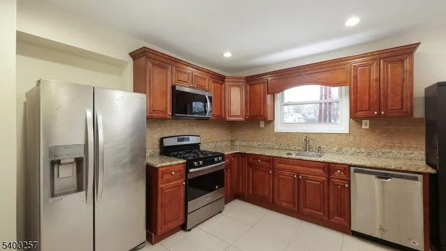 a kitchen with stainless steel appliances granite countertop a refrigerator stove and sink