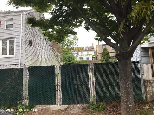 a front view of a house with a tree