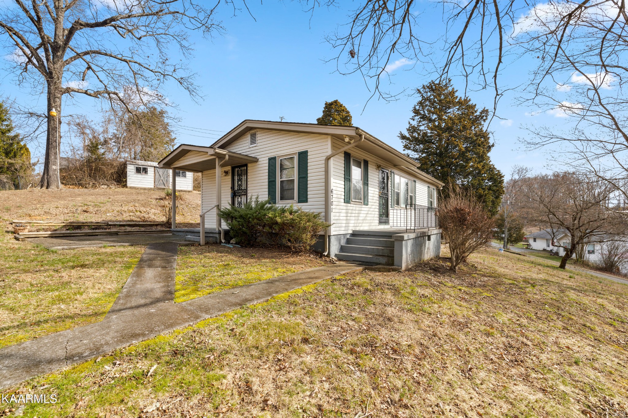 6701 Cate Road Powell, TN 37849 - Photo 4 of 18 a front view of a house with a yard covered with snow and trees