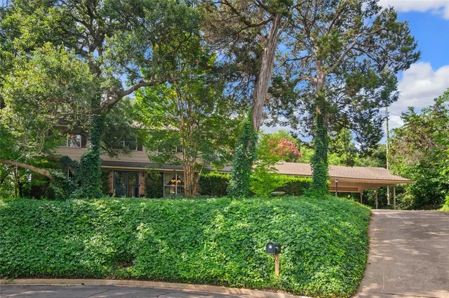 a view of a house with a yard and a tree
