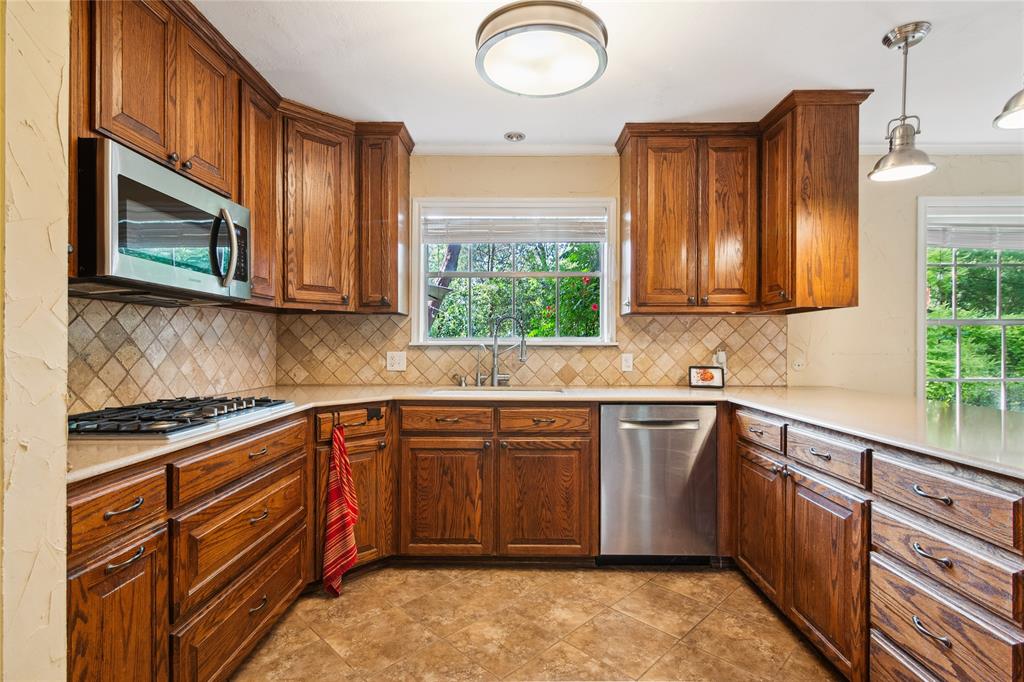 4104 Evergreen Drive Waco, TX 76708 - Photo 10 of 36 a kitchen with stainless steel appliances granite countertop a sink and dishwasher a stove top oven with wooden floor