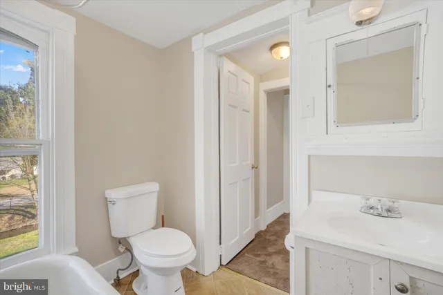 a bathroom with a toilet sink and mirror