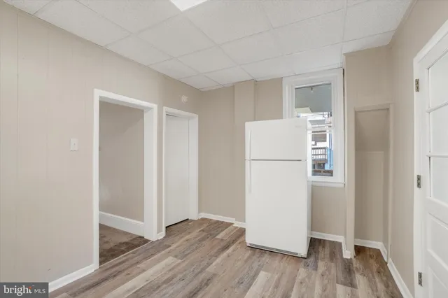 a view of a kitchen with a refrigerator and wooden floor