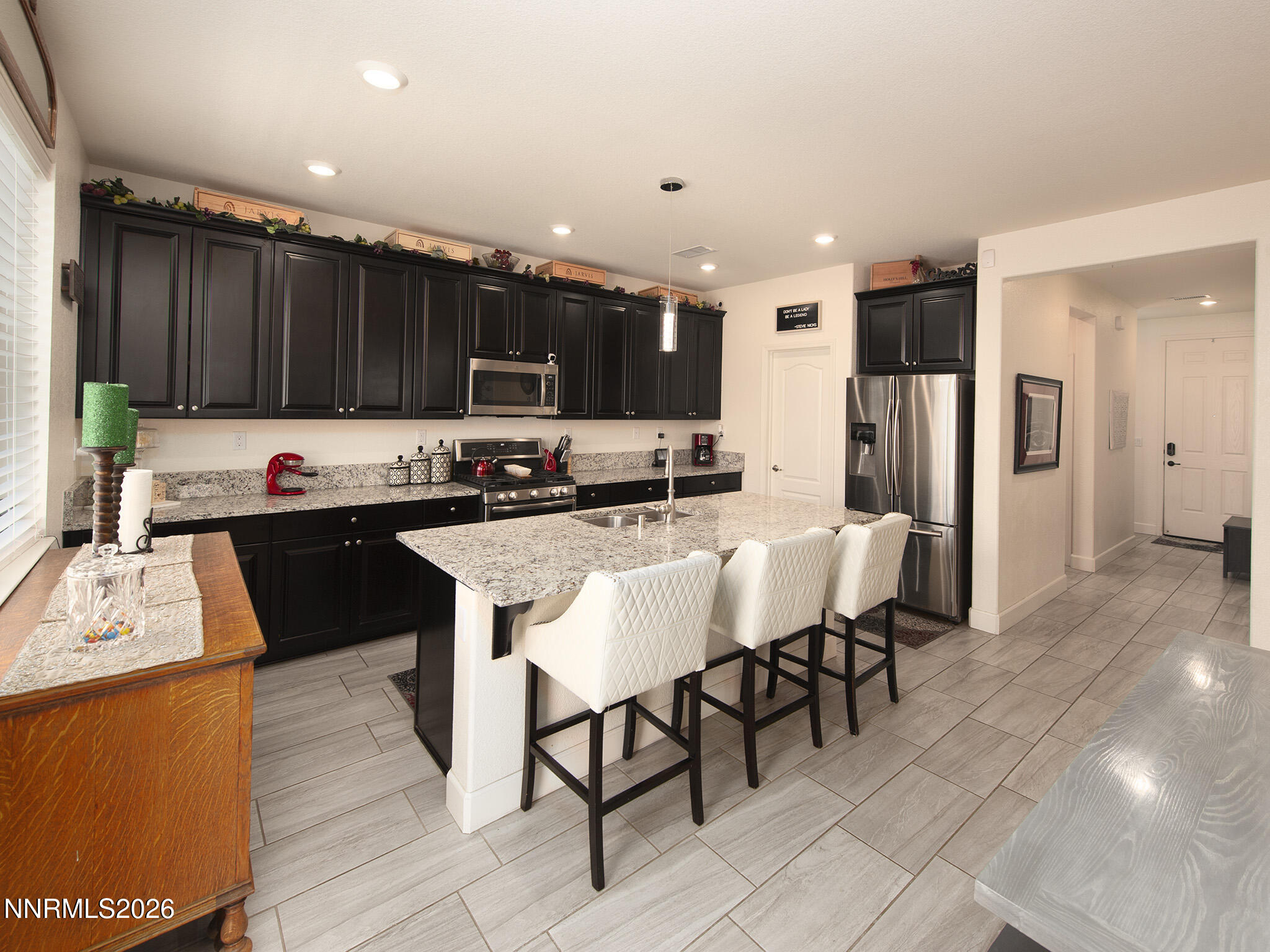 9766 Pachuca Drive Reno, NV 89521 - Photo 10 of 59 a kitchen with stainless steel appliances kitchen island granite countertop a refrigerator a stove a sink and a oven
