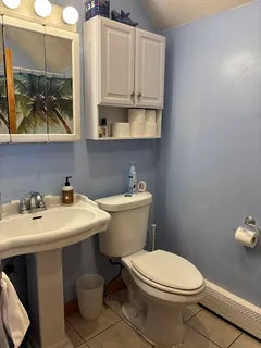a bathroom with a toilet a sink and mirror