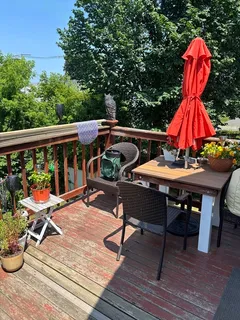 an outdoor sitting area with furniture and wooden floor