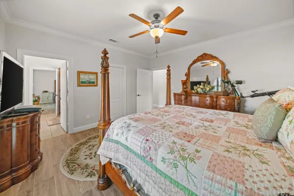 a bedroom with a bed and a flat tv screen on dresser