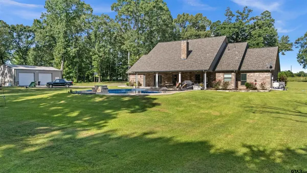 a aerial view of a house with swimming pool garden and patio