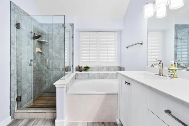 a bathroom with a tub sink and mirror