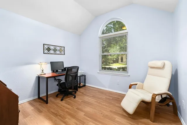 a view of a workspace with furniture and a window