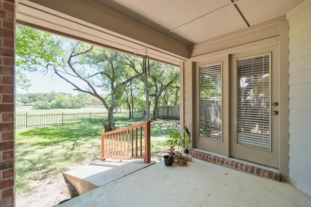 a view of backyard with large trees and plants