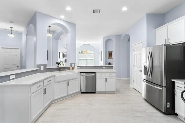 a large kitchen with white cabinets and stainless steel appliances