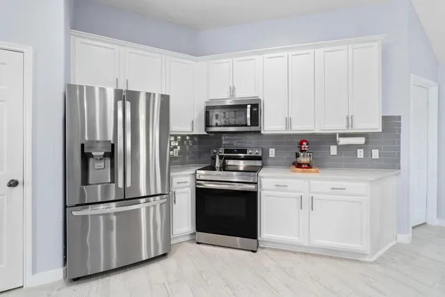 a kitchen with cabinets stainless steel appliances and a counter space