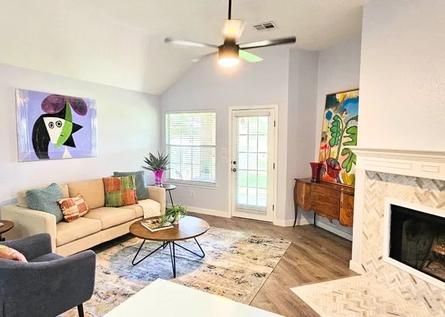 a living room with furniture a chandelier and a fireplace