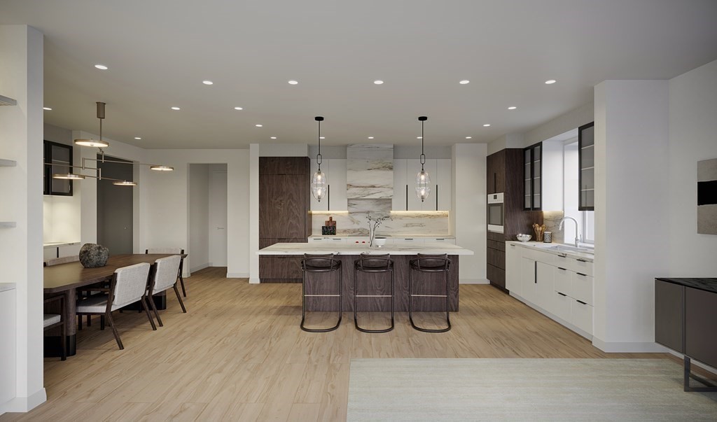 148 Weston Road, Unit 203 Wellesley, MA 02482 - Photo 9 of 11 a kitchen with kitchen island stainless steel appliances a table and chairs in it