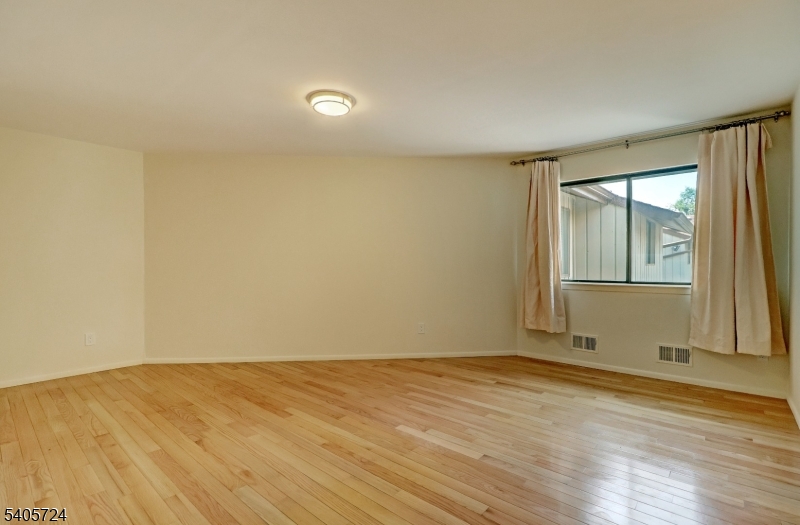 250 Ridgedale Avenue, Unit 4 Florham Park, NJ 07932 - Photo 14 of 24 an empty room with wooden floor and windows