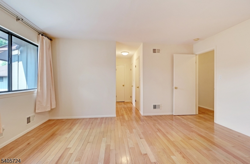 250 Ridgedale Avenue, Unit 4 Florham Park, NJ 07932 - Photo 15 of 24 a view of an empty room with wooden floor and a window