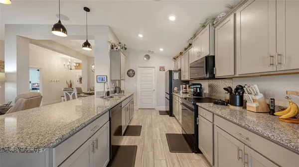 a open kitchen with stainless steel appliances granite countertop a sink stove and refrigerator