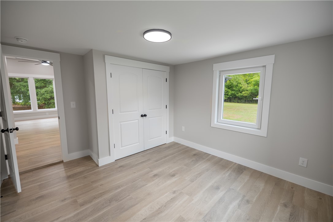 2817 Broadway Lake Road Anderson, SC 29621 - Photo 26 of 41 A well-lit bedroom features durable hardwood flooring and a picturesque window overlooking the lush green surroundings.