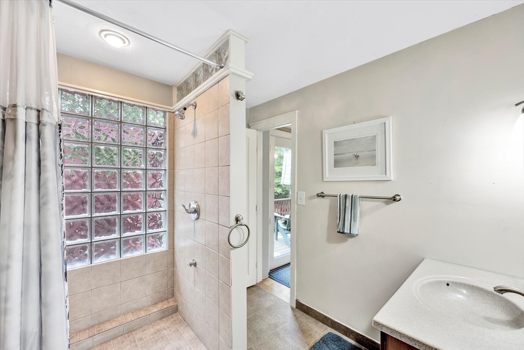 67 Cliff Road Bourne, MA 02532 - Photo 22 of 36 a bathroom with a tub sink and mirror