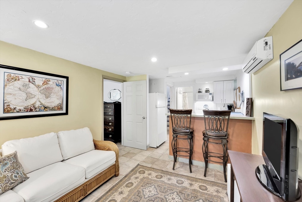 67 Cliff Road Bourne, MA 02532 - Photo 34 of 36 a living room with furniture a flat screen tv and a refrigerator