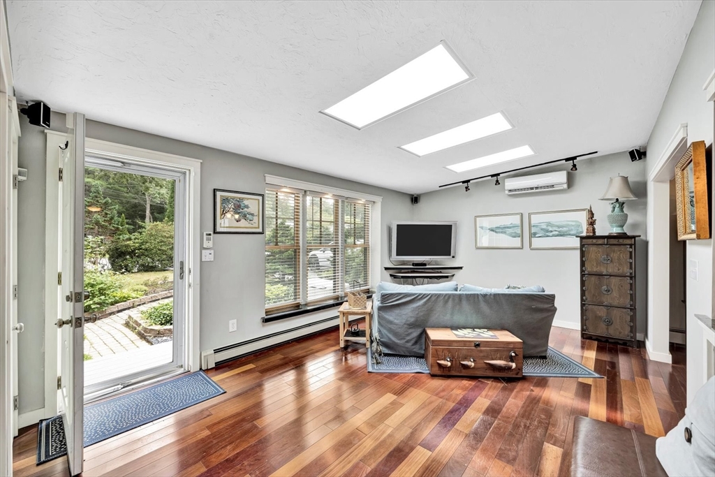 67 Cliff Road Bourne, MA 02532 - Photo 7 of 36 a living room with furniture a flat screen tv and floor to ceiling window