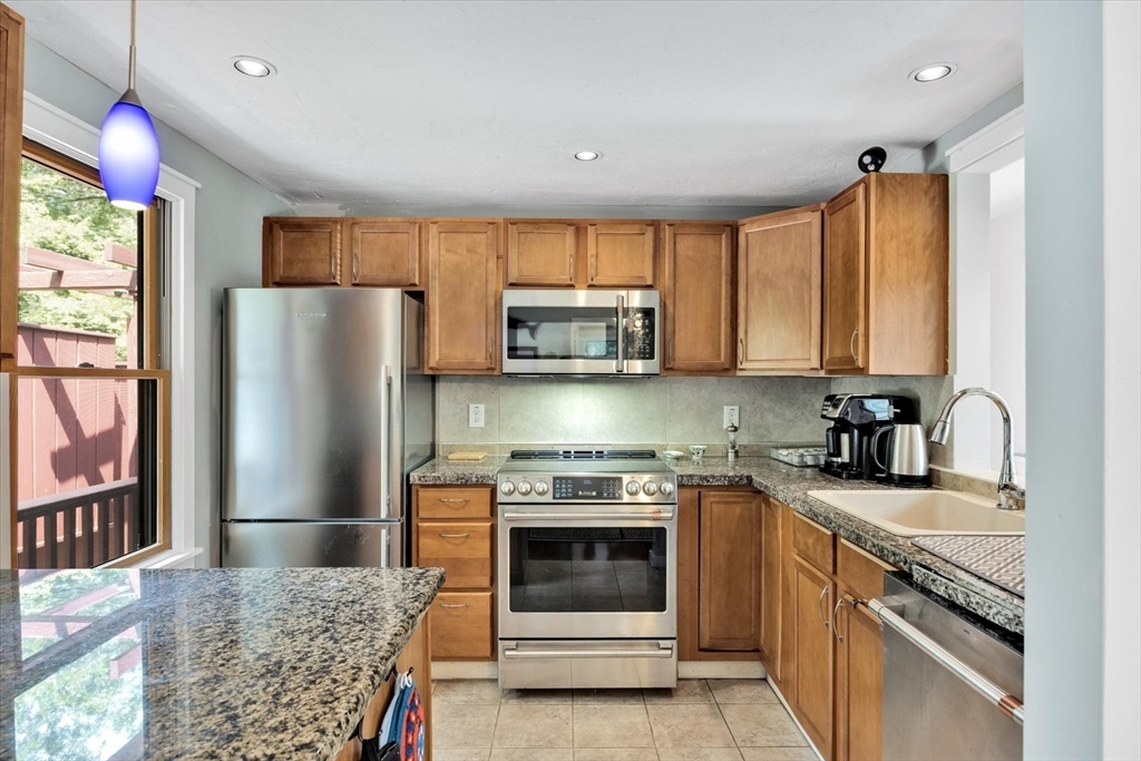 67 Cliff Road Bourne, MA 02532 - Photo 10 of 36 a kitchen with granite countertop a refrigerator stove and microwave