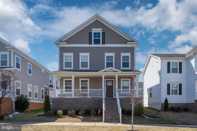 a front view of a house with yard and parking