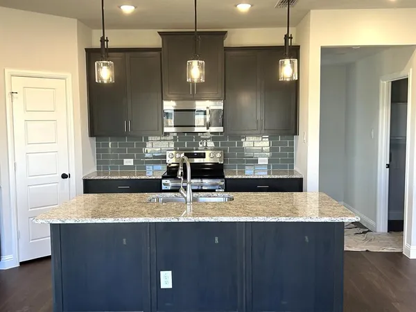 a view of kitchen island a sink wooden cabinet and living room view