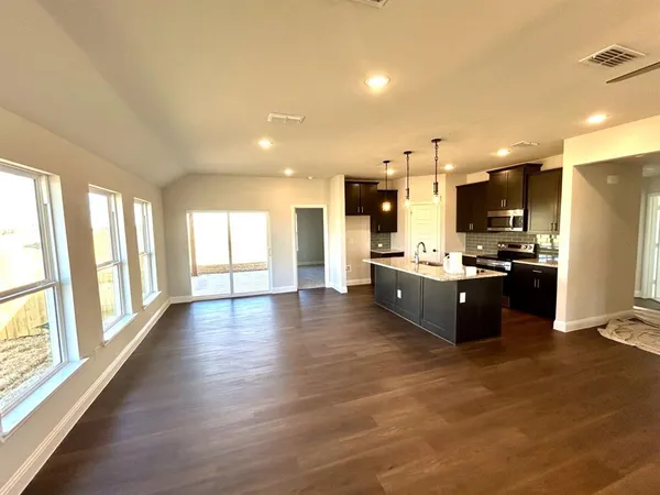 a large kitchen with a large counter top stainless steel appliances and windows