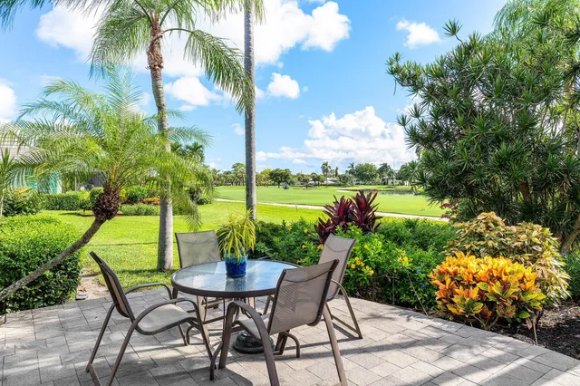 a view of a house with a big yard plants and large trees