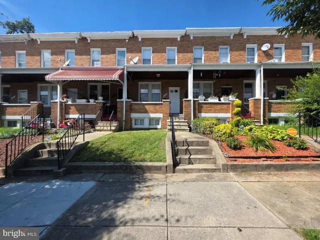 a front view of a building with garden and seating area