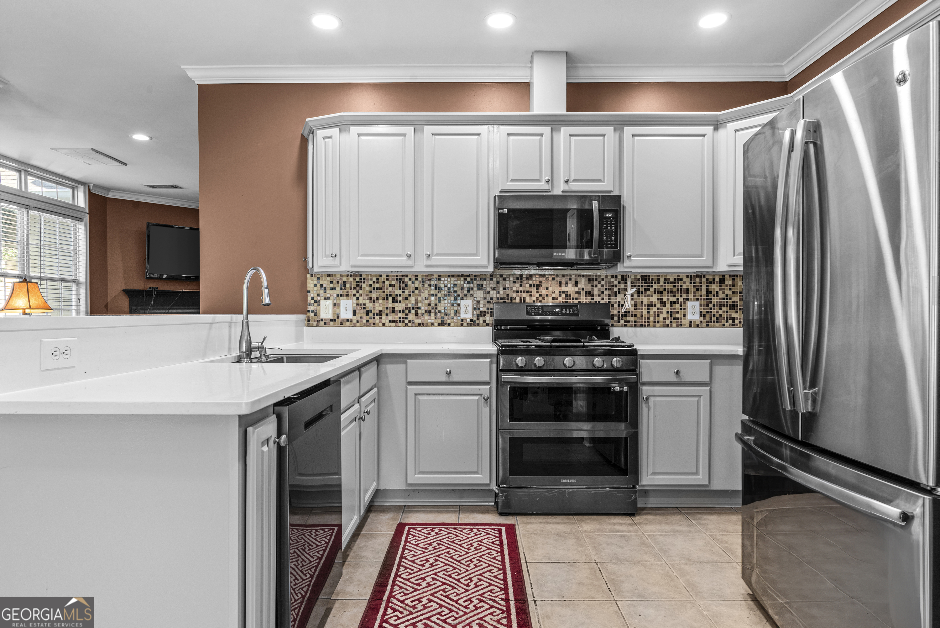 1141 Whispering Lakes Trail Madison, GA 30650 - Photo 11 of 40 a kitchen with stainless steel appliances a stove sink and microwave