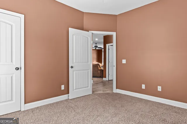 an empty room with closet and a hallway