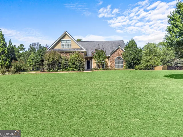 a view of a house next to a yard with big trees