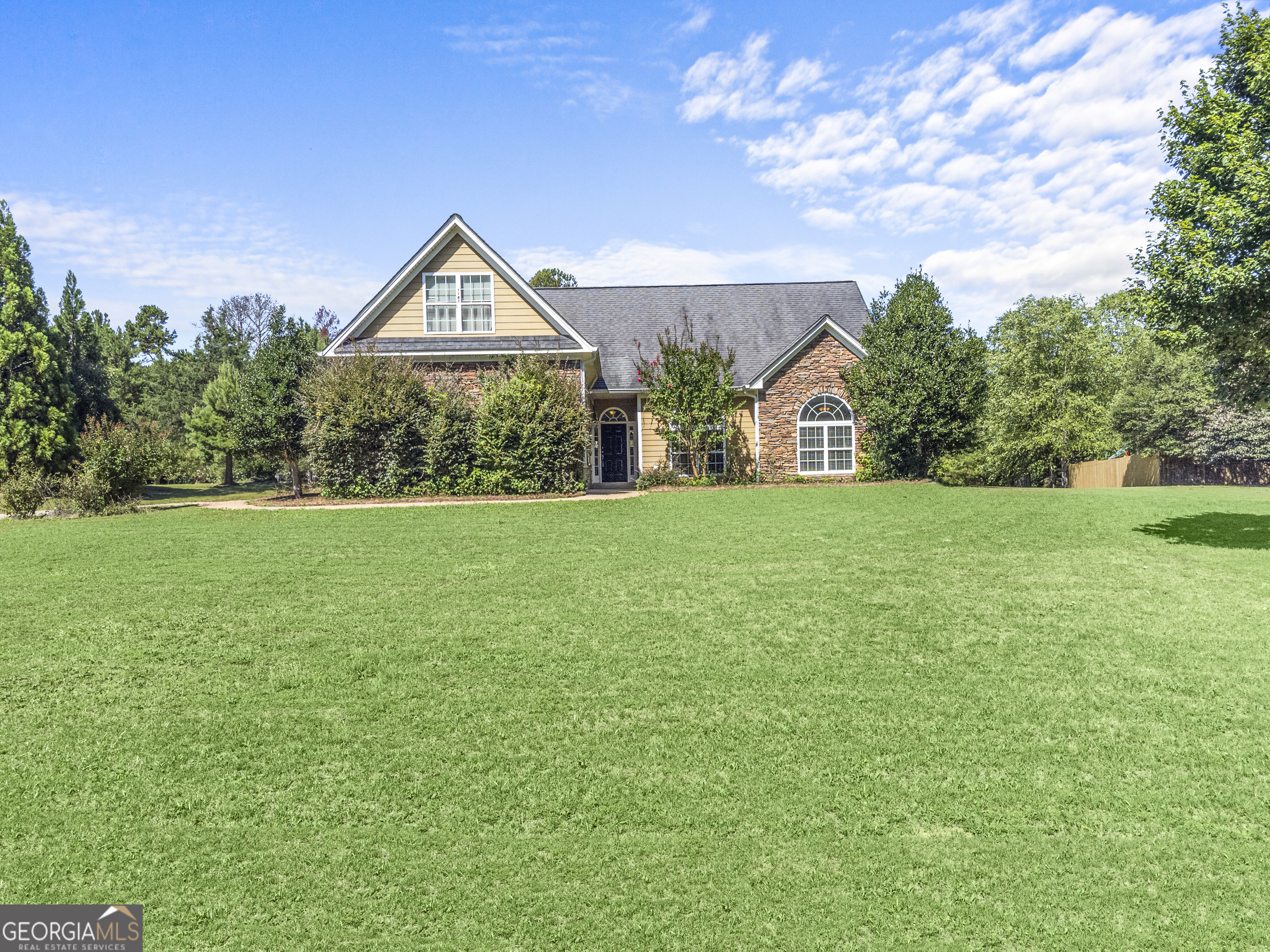 1141 Whispering Lakes Trail Madison, GA 30650 - Photo 2 of 40 a view of a house next to a yard with big trees