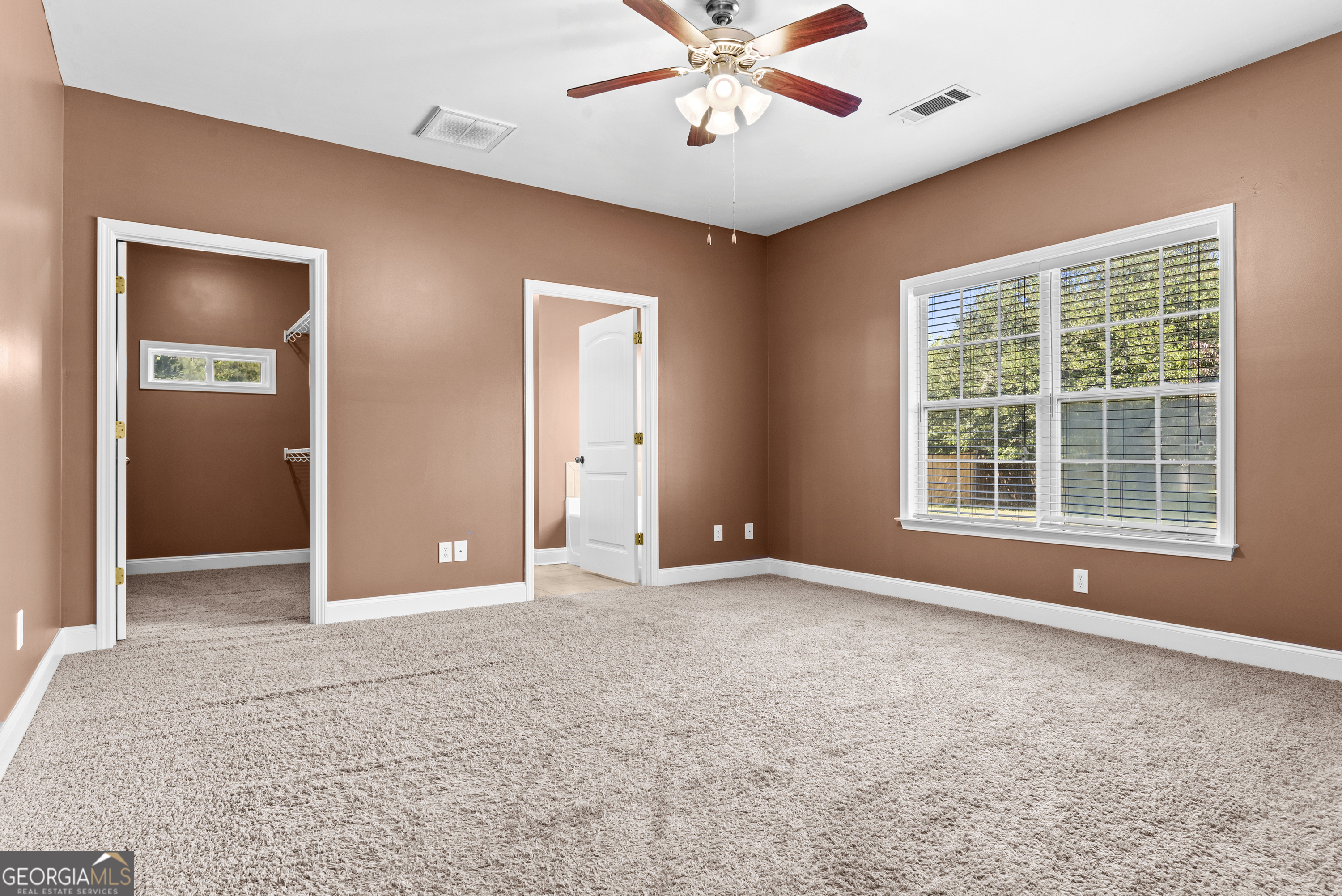 1141 Whispering Lakes Trail Madison, GA 30650 - Photo 23 of 40 an empty room with a ceiling fan and window