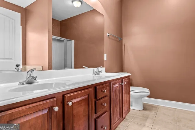 a bathroom with a granite countertop toilet a sink and a mirror
