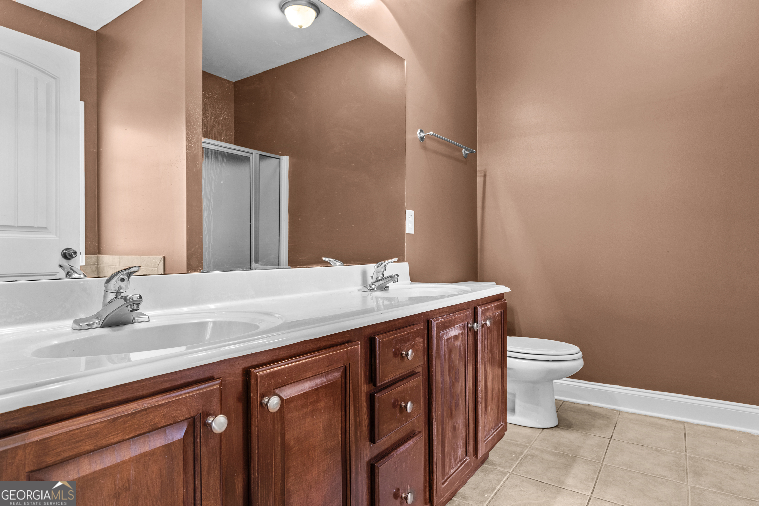 1141 Whispering Lakes Trail Madison, GA 30650 - Photo 26 of 40 a bathroom with a granite countertop toilet a sink and a mirror
