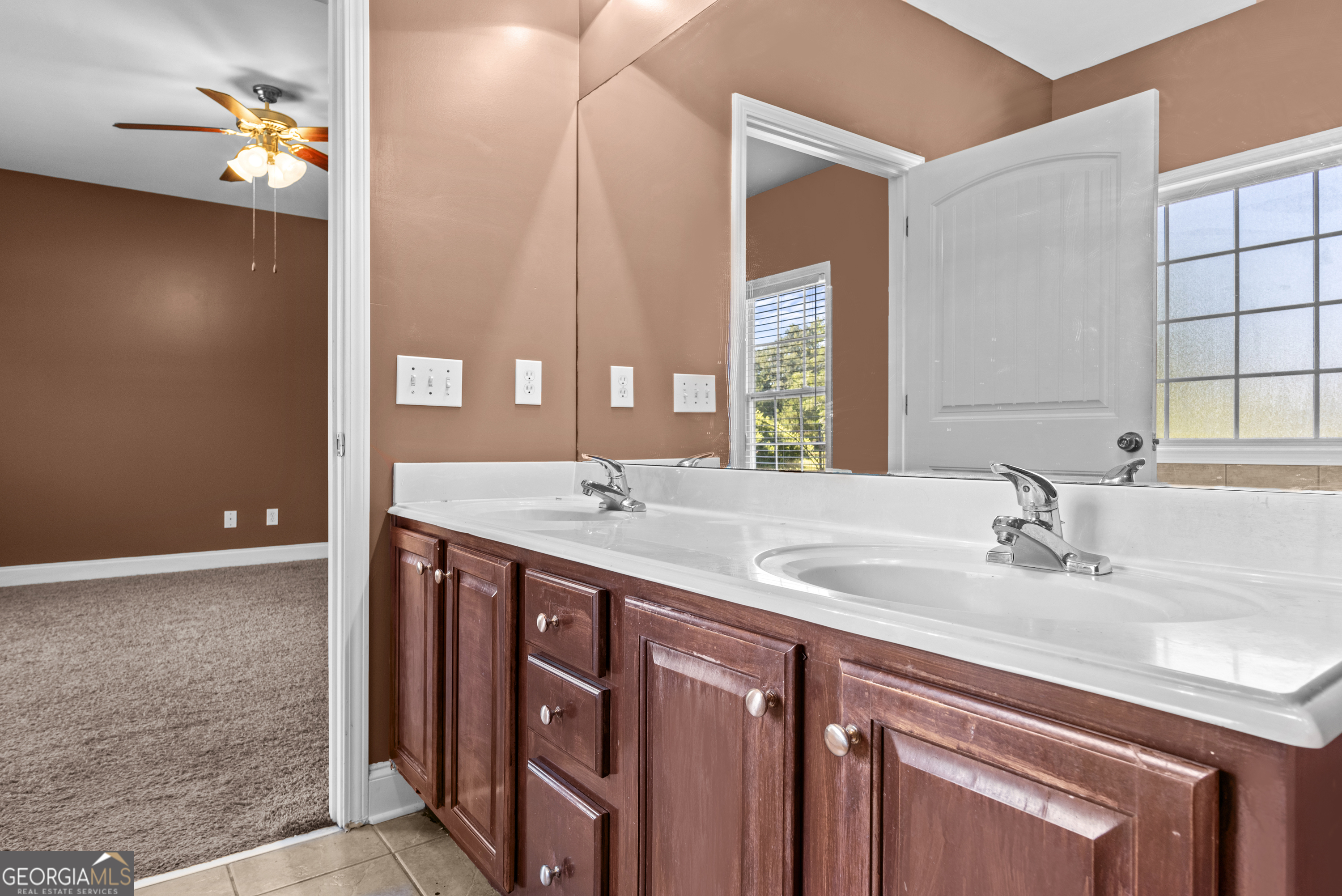 1141 Whispering Lakes Trail Madison, GA 30650 - Photo 27 of 40 a bathroom with a double vanity sink and a mirror