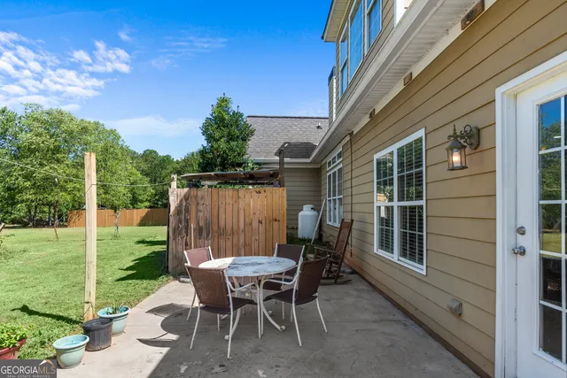 a backyard of a house with table and chairs